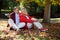 Contemplated couple sitting on autumn leaves