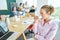 Contemplative female entrepreneur drinking coffee while staring at laptop near team discussing in conference room