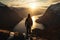 Contemplative person sitting on the edge. Stunning view in mountainous landscape.