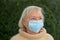 Contemplative senior woman wearing a face mask