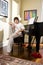 Contemplative teenage boy sitting on piano bench