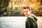 Contemplative teenage boy sitting beside river