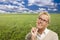 Contemplative Woman in Grass Field Looking Up and Over