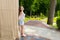 Contemplative young woman standing near wall in a park