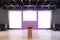 Contemporary auditorium interior with empty posters and concrete flooring with reflections. Speaker and presentation concept. Mock