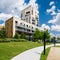 Contemporary block of flats in green area with blue sky and white clouds above