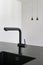 A contemporary designed black colored kitchen faucet