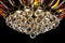 Contemporary gold chandelier isolated on black background. Crystal chandelier decorated amber crystals close-up