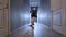 Contemporary hip hop dancer young man dancing in a ray of light in a long dark hallway with lots of white doors on both