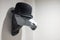 Contemporary horse shape hat holder with a black bowler hat