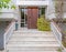 A contemporary house entrance marble stairs and natural wood door,