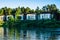 Contemporary houses next to lake and trees. Typical facade of a modern town suburban house near the pond