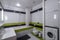 Contemporary interior of bathroom in modern flat. Black and green tile. Bath with shower. Toilet. Washing machine.