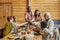 Contemporary interracial family clinking with drinks over served table