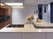 Contemporary kitchen with hob and built-in appliances, white and hardwood facade. concrete table top bar