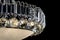 Contemporary silver chandelier isolated on black background. Crystal chandelier close-up