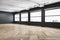 Contemporary spacious concrete gallery interior with wooden flooring and windows with city view.