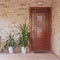 A contemporary stonewall house with wooden entrance door and flower plants