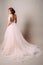 Contemporary wedding gown. Ginger bride in pink tulle wedding dress in studio. Beautiful bride in purple wedding gown with back de