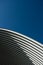 Contemporary white grey metal curve architecture on blue sky background