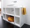 Contemporary white painted MDF bathroom unit, with colourful basket and black vinyl flooring