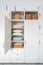 contemporary wooden closet with bedclothes and rattan basket