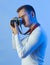 Contemporary young man posing in various poses in studio.Futuristic neon lighting.Taking pictures with analog camera