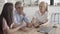 Content colleagues watching tablet screen and sitting at table