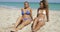 Content women sunbathing on sand