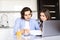 Content young couple examining papers while filing income tax returns in kitchen