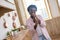 Contented african woman in pink clothes singing in the kitchen