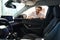 Contented car dealership client inspecting automobile interior