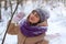 A contented Caucasian woman walks in a winter park. Young woman against a snow-covered park on a sunny day