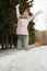 A contented Caucasian woman walks in a winter park. Young woman against a snow-covered park on a sunny day