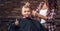 Contented cute preschooler boy shows thumbs up while getting a haircut. Children hairdresser with scissors and comb is