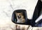 Contented face of a Corgi dog is reflected in the mirror of a car during a vacation trip