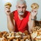 A contented gray-haired man at a table with mushrooms