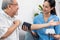 A contented retired man having a blood pressure check by his personal caregiver.