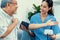 A contented retired man having a blood pressure check by his personal caregiver.