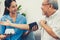 A contented retired man having a blood pressure check by his personal caregiver.