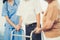 Contented senior man was helped on folding walker by his wife and caregiver.