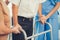 Contented senior man was helped on folding walker by his wife and caregiver.