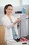 contented woman sorting laundry in home