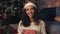 Contented Young Girl Wearing Santas Hat and White Pullover, Holding Red Gift Box, Looking to Camera Smiling, Looking