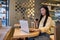 Contented young woman using her laptop during the coffee break