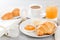 Continental breakfast with a croissant, boiled egg. Coffee or tea with milk, a glass of juice, buns, butter, jam