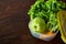 Continental breakfast with fresh pastry, fruits, greenery and beverages over light textured background, top view,