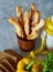 Continental breakfast with fresh pastry, vegetables, greenery and beverages over light textured background, top view,