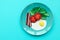 Continental breakfast made from paper: fried egg, tomato, bacon, spinach and arugula on blue background. Minimal, creative,