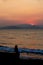 Contour of girl  that watching on sunset, sitting on pier